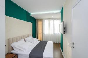 a bedroom with a bed with a green accent wall at Mashtots Avenue 31 in Yerevan