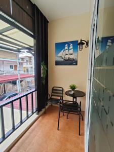 a balcony with a table and chairs and a sailboat at Chotam House in Nathon Bay