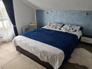 a bedroom with a large bed with a blue wall at Vila Sebas in Zărneşti