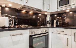 a kitchen with white cabinets and a stove top oven at Garden Suite in Binz