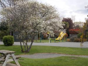 a park with a picnic table and a playground at Rangiora Lodge Motel in Rangiora