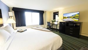 a hotel room with a bed and a flat screen tv at Beacon Inn & Suites in Lincoln