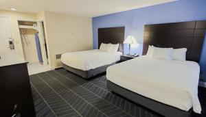 a hotel room with two beds and a bathroom at Beacon Inn & Suites in Lincoln
