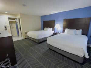 a hotel room with two beds and a bathroom at Beacon Inn & Suites in Lincoln
