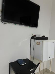 a table with a chair and a tv on a wall at Hotel Medellin in Santa Marta