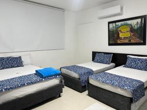 a room with three beds in a room at Hotel Medellin in Santa Marta +27 photos