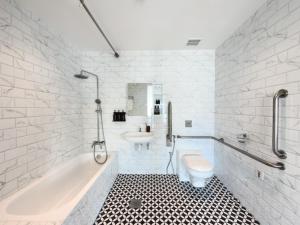 a bathroom with a tub and a sink and a toilet at The White House - Serviced Residences by Cove & Belle Living in Singapore +42 photos