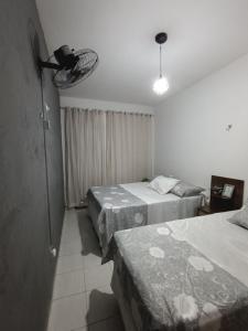 a bedroom with three beds and a room with a window at Apartamento da Jack in Campina Grande