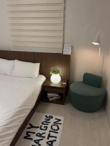 a bedroom with a bed and a green chair at 4 Beds Busan Gwangalli Big Star Stay in Busan
