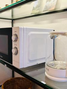 a white microwave oven sitting on a shelf at 4 Beds Busan Gwangalli Big Star Stay in Busan