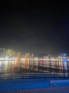 a view of a city at night with the water at 4 Beds Busan Gwangalli Big Star Stay in Busan