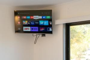 a flat screen tv hanging on a wall next to a window at Cabaña El Quillay in Santa Cruz