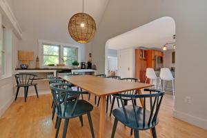 a dining room and kitchen with a wooden table and chairs at Tidepools Retreat Poolside Family Fun in York