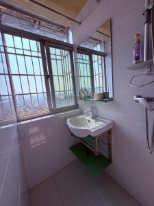 a white bathroom with a sink and windows at Ek民宿 in Beihai +33 photos