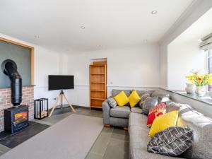 a living room with a couch and a fireplace at The Stables - Uk49089 in Crediton