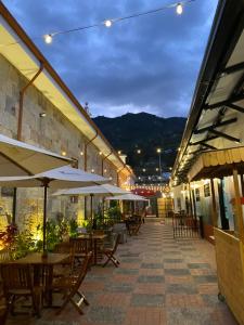 an outdoor patio with tables and umbrellas at night at Quinta Sans-Soucis in Choachí