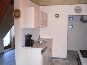 a kitchen with white cabinets and a sink at Ferienwohnung Brockenblick in Halberstadt
