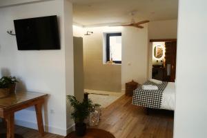 a living room with a television on a wall at Marchena de los Olivos in Peñolite