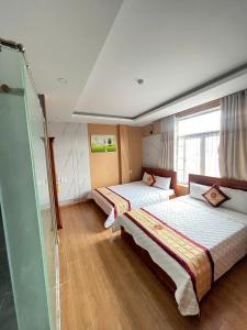 a bedroom with two beds and a shower at Hùng Thi Hotel in Cái Răng