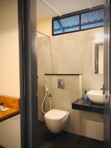 a bathroom with a toilet and a sink at Hill View Heights Wayanad in Meppādi +19 photos