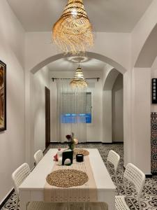 a dining room with a white table and chairs at Casa Norte in Tétouan
