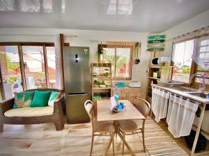 a kitchen with a refrigerator and a table and chairs at Green hill in Paea