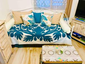 a bed with a blue and white blanket and pillows at Green hill in Paea
