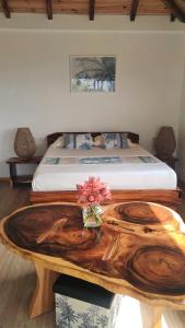 a bedroom with a wooden table with a bed at Aimeho Bungalow in Paopao