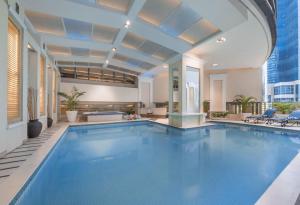 a large swimming pool in a building with a building at Discovery Suites Manila, Philippines in Manila