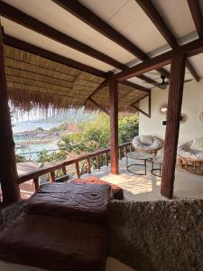 a porch with a bed and a view of the ocean at Suncliff Resort in Haad Rin