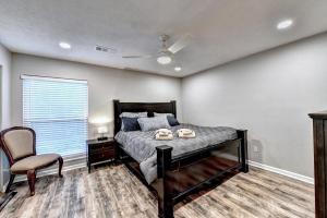 a bedroom with a bed and a chair and a window at Alpharetta Dreaming in Alpharetta