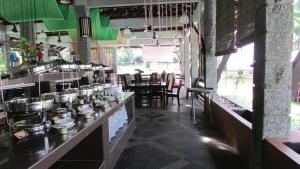 un restaurante con un bar con mesa y sillas en Felda Residence Hot Springs, en Sungkai
