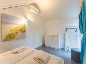 a bedroom with a bed and a painting on the wall at Coastal Family Escape with Enclosed Garden in Renesse