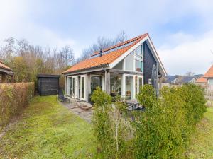a house with an orange roof on a yard at Coastal Family Escape with Enclosed Garden in Renesse