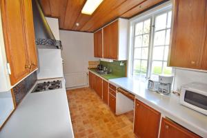 a kitchen with white appliances and wooden cabinets at Ribbingshof Herrgård - Flygeln in Norra Vi