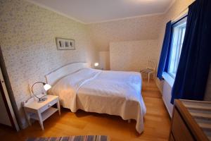 a bedroom with a white bed and a window at Ribbingshof Herrgård - Flygeln in Norra Vi
