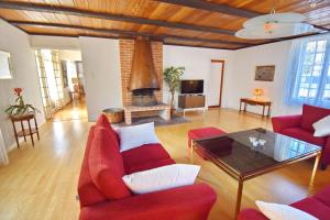 a living room with red furniture and a fireplace at Ribbingshof Herrgård - Flygeln in Norra Vi