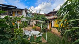 a garden with a table and chairs in front of a house at Pousada Ora Pro Nobis in Catas Altas
