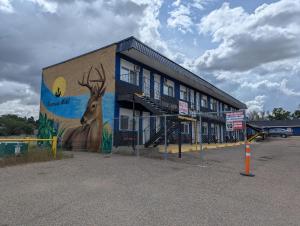 a building with a painting of a deer on it at Riverside Motel & Suites in Medicine Hat