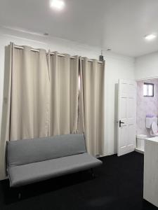 a room with curtains and a bench and a door at Colony Stay in Paramaribo