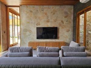 a living room with a couch and a tv at Villa Sucasas, Luxury Pool Villa Nusa Dua, Bali in Nusa Dua
