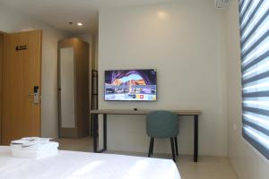a room with a desk and a tv on a wall at The Perch Hostel in Olongapo