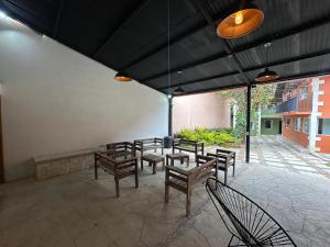 a group of tables and benches under a building at La Escondida Cabañas in Mineral del Monte