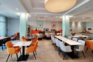 a dining room with white tables and chairs at Garner Hotel Wiesbaden City by IHG in Wiesbaden