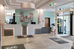 an office with a lobby with a reception desk and posters at Garner Hotel Wiesbaden City by IHG in Wiesbaden