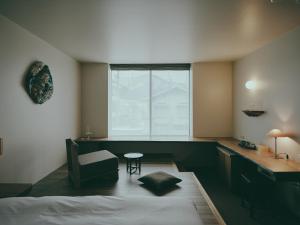 a bedroom with a bed and a chair and a window at mont - Nozawa Onsen Ski Resort in Nozawa Onsen