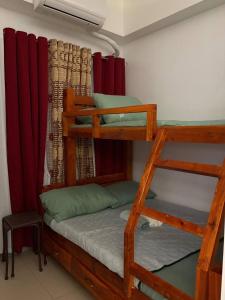 a bedroom with two bunk beds with red curtains at RD Bliss Staycation - SMDC Condo Tower B in Kaybagal