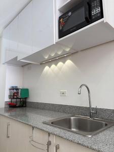 a kitchen counter with a sink and a microwave at RD Bliss Staycation - SMDC Condo Tower B in Kaybagal
