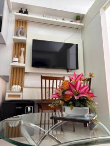 a living room with a glass table with a vase of flowers at RD Bliss Staycation - SMDC Condo Tower B in Kaybagal
