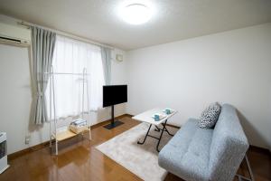 a living room with a couch and a tv at Furano Ski Frante 2 in Furano +37 photos